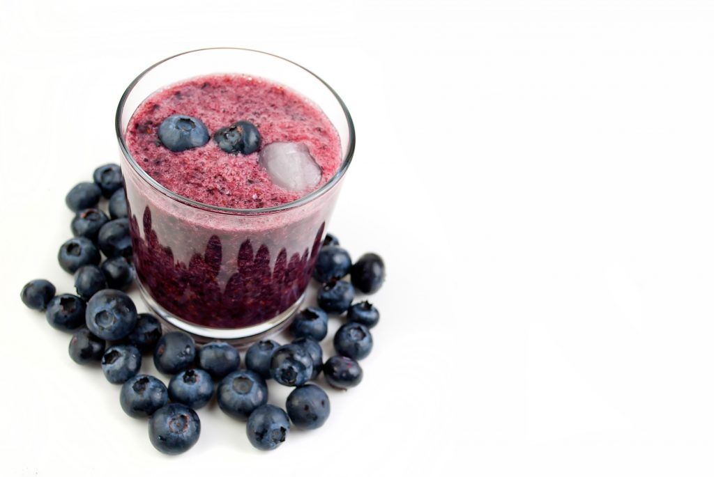 snacking in bed with a blueberry smoothie