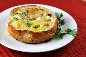 recipegirl.com Bagel Quiche on a white plate. A great breakfast in bed idea for Mother's Day.