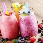 Three mason jars that have healthy smoothies in them.