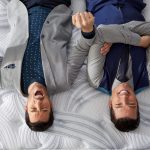 Jonathan and Drew Scott, the Property Brothers, laying upside down on a Restonic mattress.