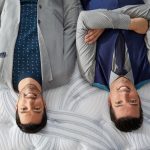 Jonathan and Drew Scott, the Property Brothers, lying on a mattress upside-down.